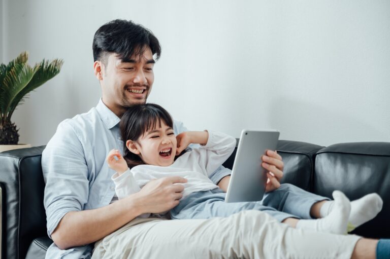 Father and daughter using ipad together at home